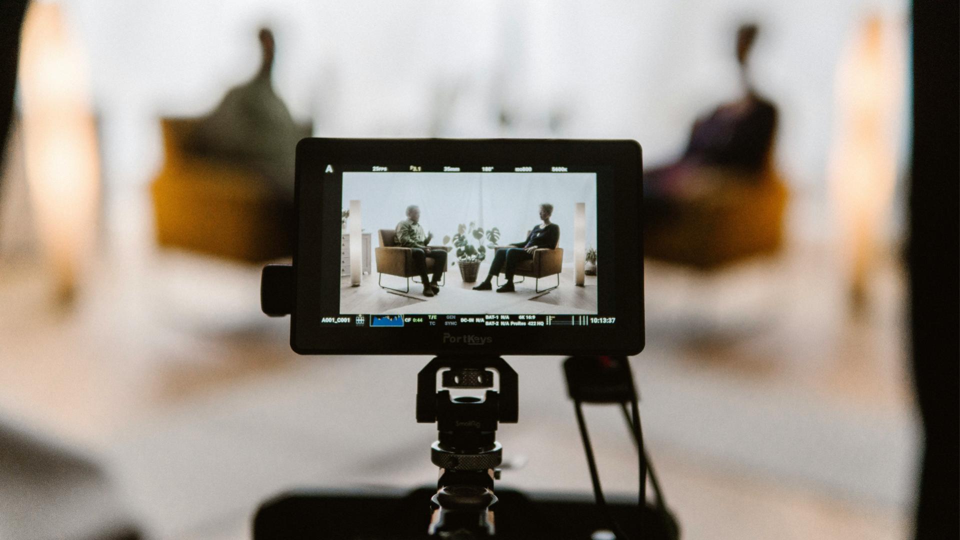 Fotografia atrás de uma câmera gravando uma entrevista